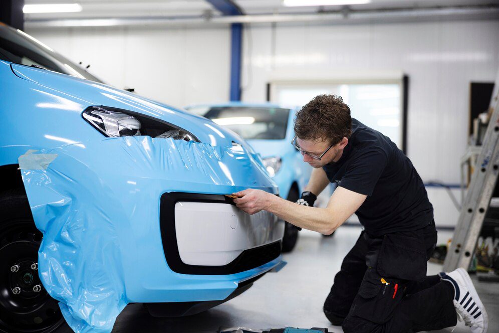 man-wrapping-car-with-blue-cover-full